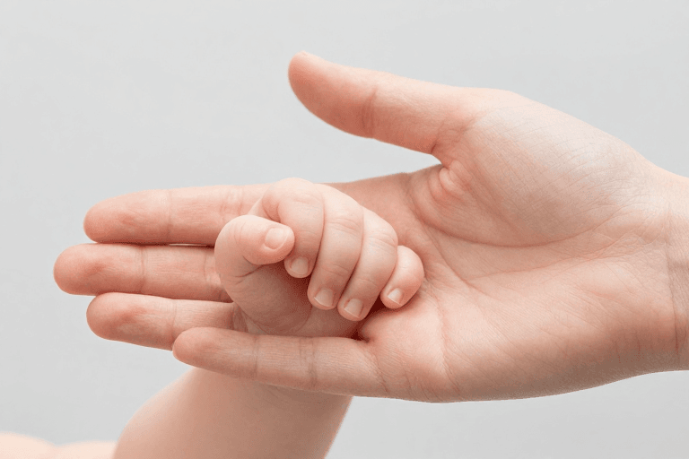 母婴健康素材：温情传递：成人手掌轻托婴儿小手的高清摄影