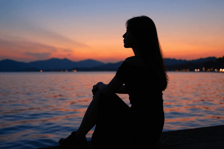 日落风景素材：夕阳湖畔剪影：孤独女性的沉思时刻