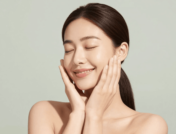 高清人像摄影素材：亚洲女性裸肩微笑：肌肤光泽的淡绿背景摄影