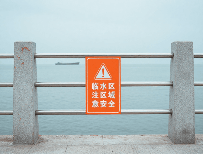 阴天气象素材：临水安全警示：橙色护栏守护宁静海域