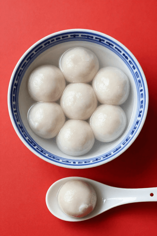 中式传统素材：青花瓷碗盛八颗白汤圆，节日美食宣传图