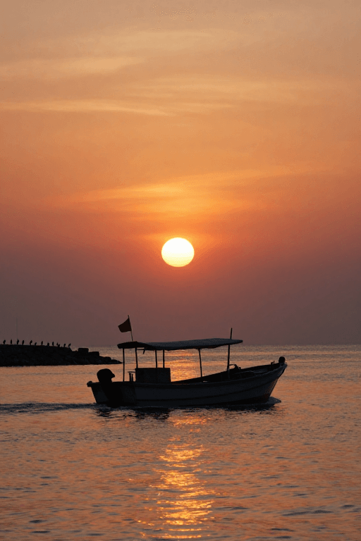 逆光拍摄素材：夕阳下渔船剪影：海上金色时光