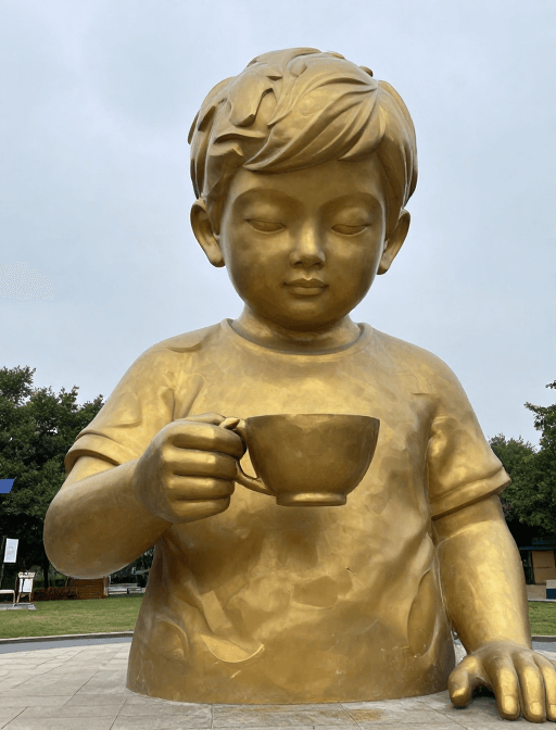 大型艺术装置素材：童心未泯：巨型孩童塑雕手持茶杯的艺术展现