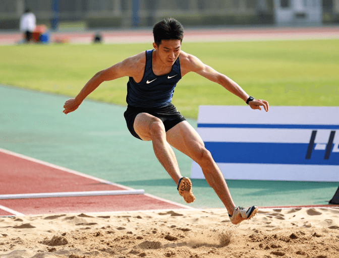 侧逆光摄影素材：深蓝Nike男选手腾空跃起瞬间