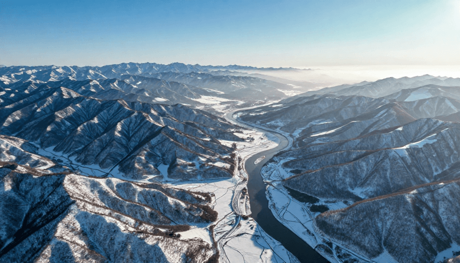 高清风景素材：冬日雪山与河流交织的航拍绝景：高对比冷调风光摄影