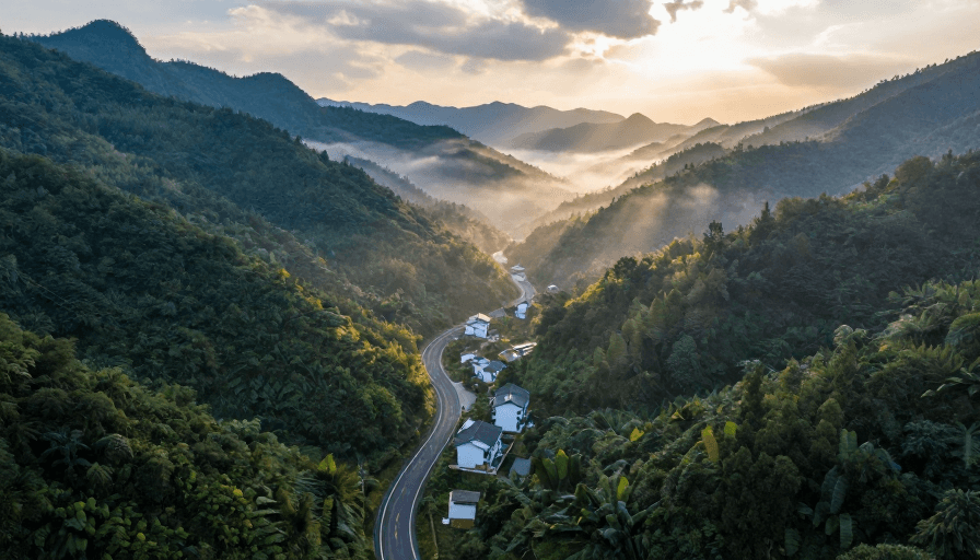 晨光摄影素材：晨光穿透云雾的山路：青绿与暖橙交织的诗意风景